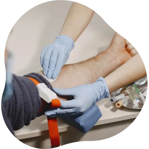 Profissional de saúde realizando coleta de sangue em paciente em laboratório parceiro Ezmedi em Vila Velha.